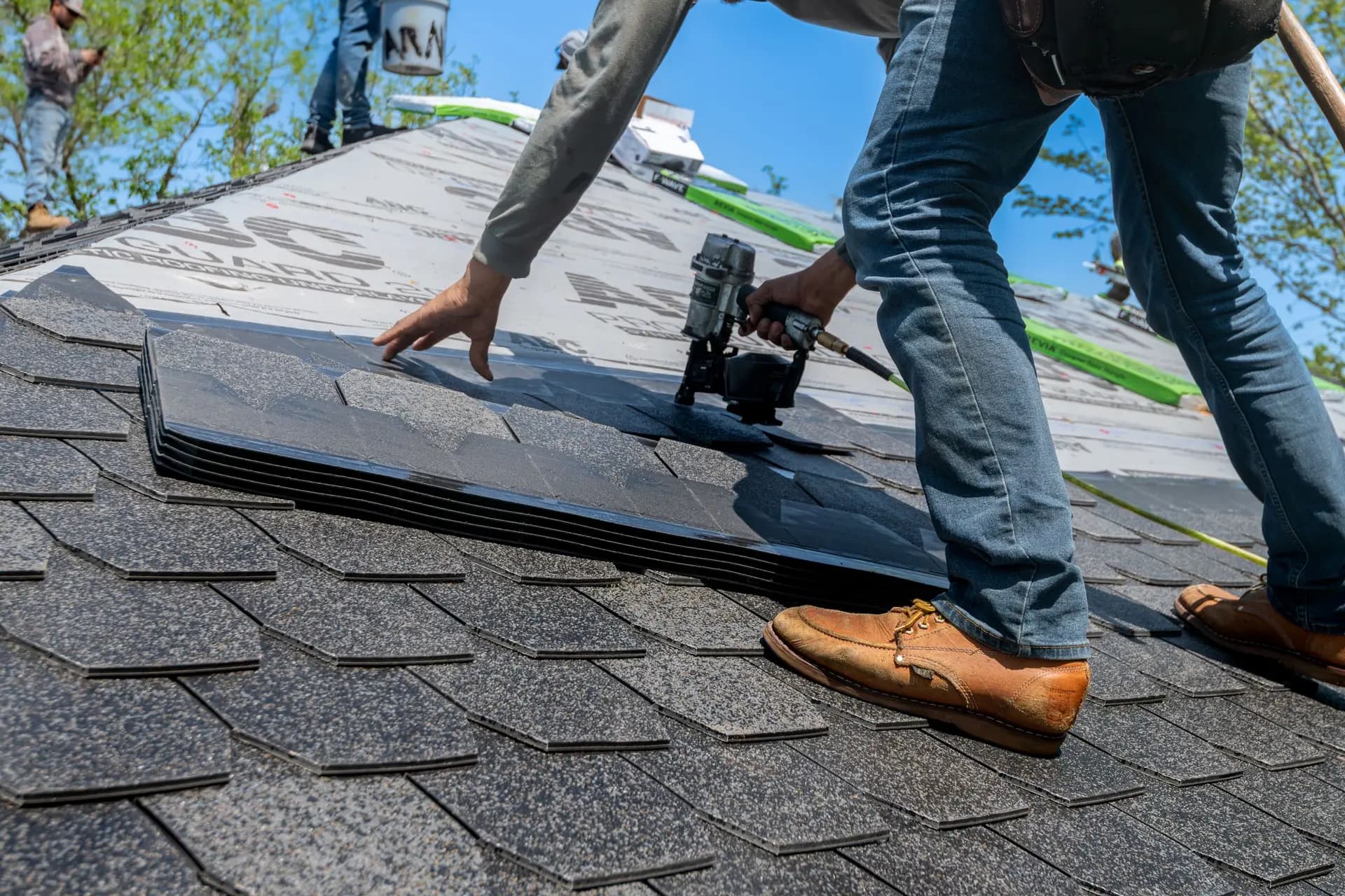 A roofer installing asphalt shingles