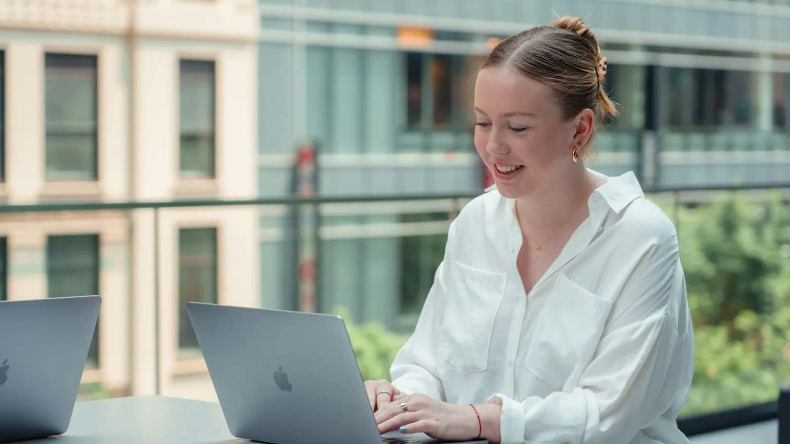 Woman typing on a laptop at a bright table